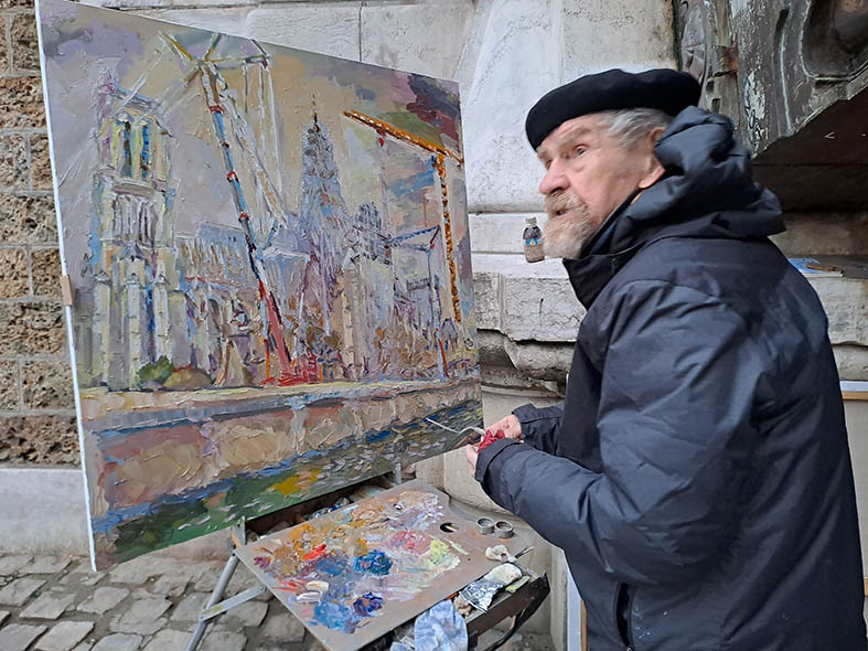 Nikolaï Kouzmine en train de peindre Notre-Dame de Paris en travaux, le 9 février 2024, au pied du « pont au Double ».